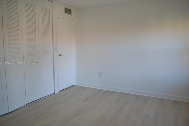 unfurnished bedroom featuring a closet and light hardwood / wood-style flooring