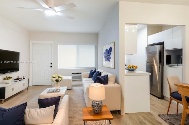 living room with a wall mounted air conditioner, light hardwood / wood-style floors, and ceiling fan