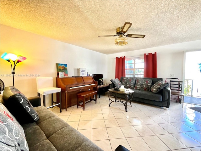 living room featuring ceiling fan, light tile patterned flooring, and a textured ceiling