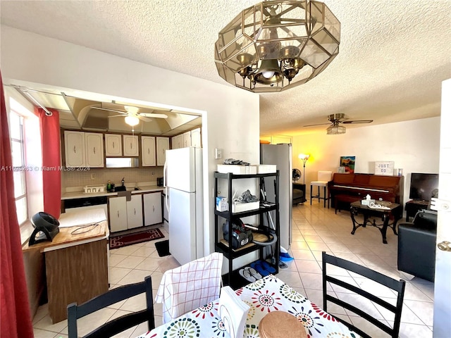 dining room with light tile patterned floors, a textured ceiling, ceiling fan, and sink