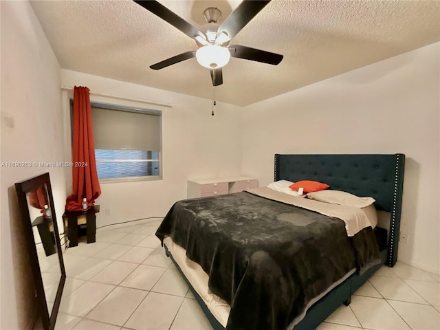 bedroom featuring light tile patterned floors, a textured ceiling, and ceiling fan