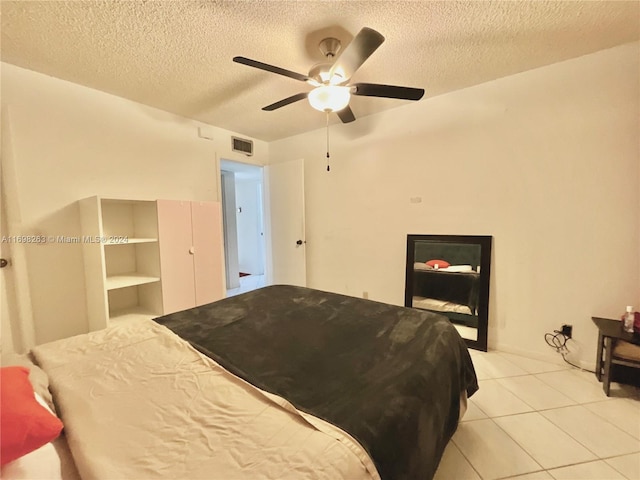 tiled bedroom featuring ceiling fan and a textured ceiling