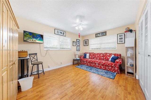 living room with ceiling fan and light hardwood / wood-style flooring