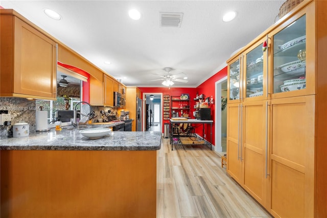 kitchen featuring kitchen peninsula, tasteful backsplash, stainless steel appliances, crown molding, and light hardwood / wood-style flooring