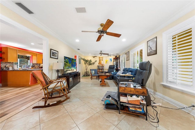 tiled living room with ceiling fan and ornamental molding