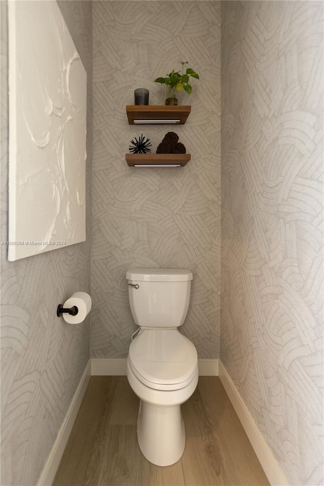 bathroom featuring wood-type flooring and toilet