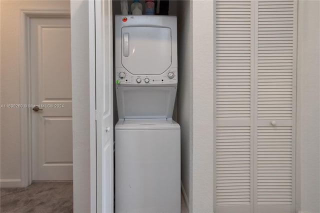 laundry room with carpet flooring and stacked washer / drying machine