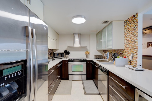 kitchen with wall chimney exhaust hood, tasteful backsplash, white cabinetry, stainless steel appliances, and beverage cooler