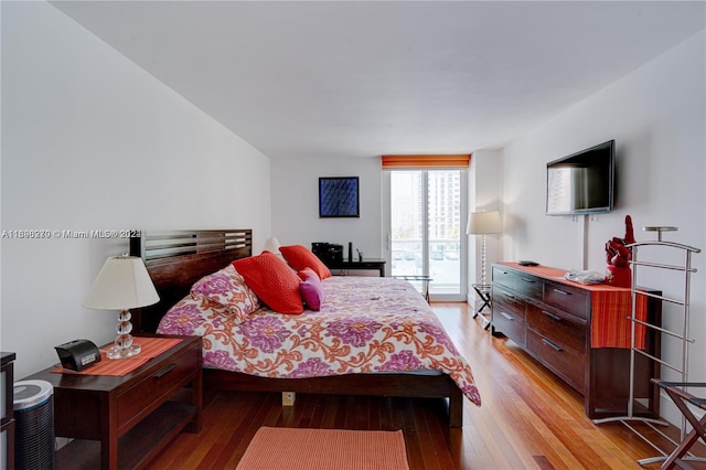 bedroom with access to exterior and light hardwood / wood-style floors