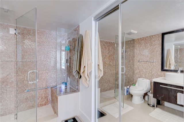 bathroom featuring tile patterned flooring, vanity, a shower with shower door, and toilet