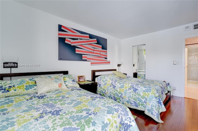 bedroom featuring dark hardwood / wood-style flooring and a closet