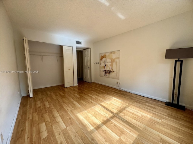 7060 Nova Dr Unit 306C, Davie, FL 33317 - unfurnished bedroom with light wood-type flooring, a textured ceiling, and a closet