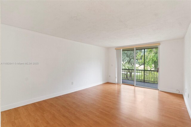 1681 NW 70th Ave Unit 204, Plantation, FL 33313 - empty room with light wood-style floors, baseboards, and a wall of windows