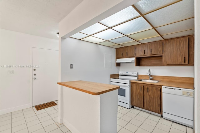 kitchen with white appliances, sink, and light tile patterned floors