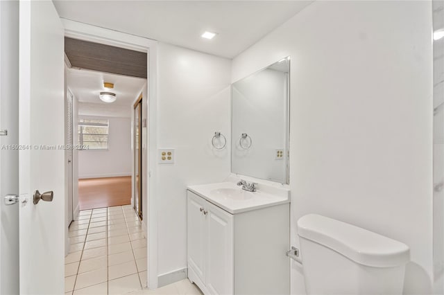 bathroom with tile patterned flooring, vanity, and toilet