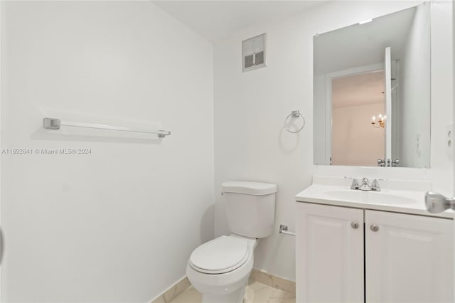 bathroom featuring vanity, a notable chandelier, and toilet