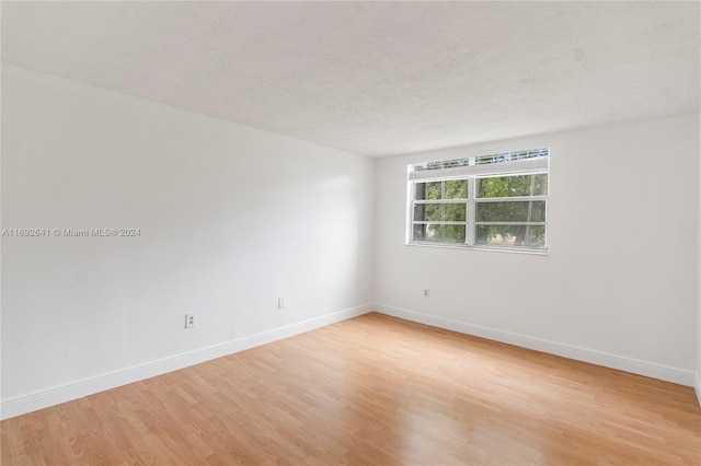 empty room with a textured ceiling and light wood-type flooring