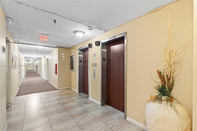 corridor featuring light tile patterned floors and elevator