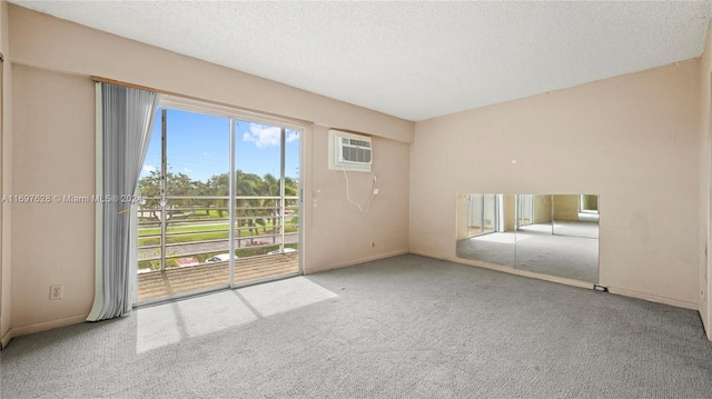 carpeted empty room with a wall unit AC, a textured ceiling, and a wealth of natural light