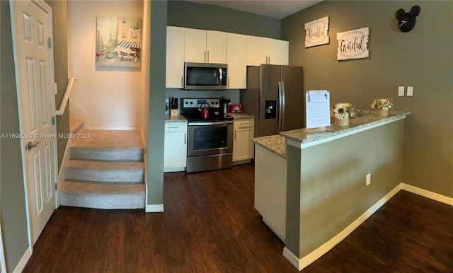 kitchen with white cabinets, dark hardwood / wood-style floors, light stone countertops, kitchen peninsula, and stainless steel appliances