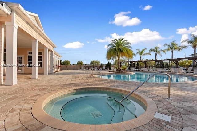 view of swimming pool featuring a community hot tub and a patio