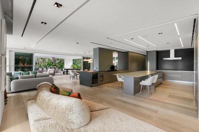 living room with floor to ceiling windows, wood walls, and light hardwood / wood-style floors