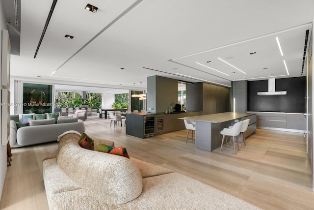 interior space featuring a breakfast bar area, plenty of natural light, beverage cooler, and a spacious island