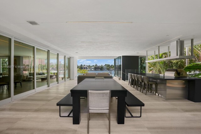 dining space with light wood-type flooring and a wall of windows