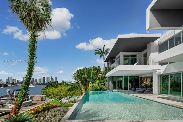 view of swimming pool with a patio and a water view