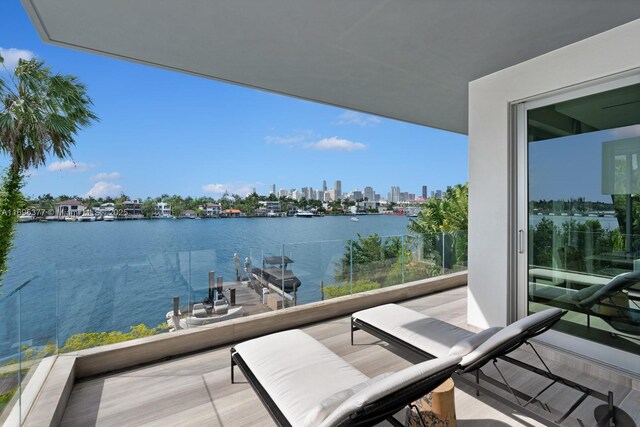 bedroom featuring floor to ceiling windows, a water view, and light hardwood / wood-style floors