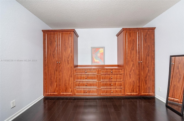 bonus room featuring dark hardwood / wood-style flooring and a textured ceiling