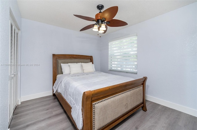 bedroom featuring ceiling fan, a textured ceiling, and hardwood / wood-style flooring