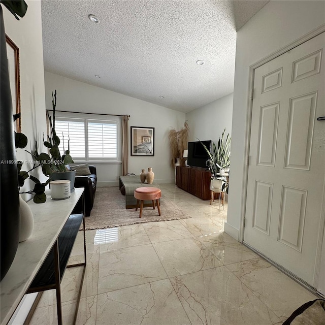 living room featuring a textured ceiling and vaulted ceiling