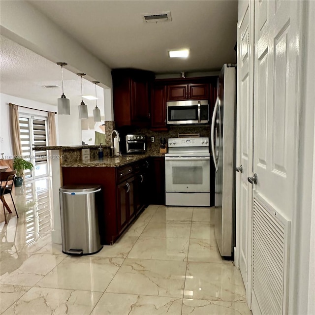 kitchen with sink, hanging light fixtures, stainless steel appliances, kitchen peninsula, and decorative backsplash