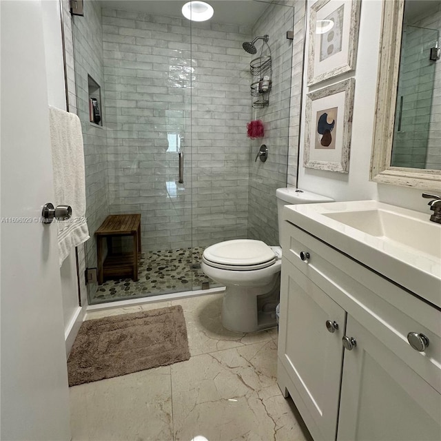 bathroom with vanity, a shower with shower door, and toilet