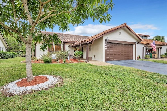 mediterranean / spanish-style home with a garage and a front yard