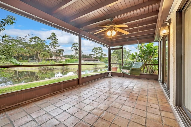 unfurnished sunroom with beamed ceiling, a water view, ceiling fan, and wooden ceiling