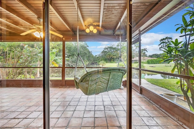 unfurnished sunroom with beamed ceiling, plenty of natural light, a water view, and wooden ceiling