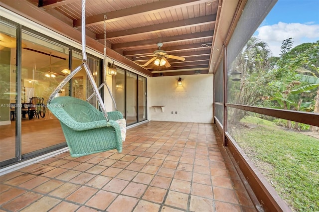 unfurnished sunroom featuring ceiling fan, beamed ceiling, and wooden ceiling