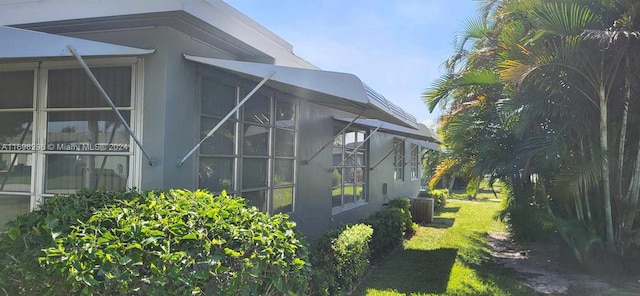 view of home's exterior with a lawn and cooling unit