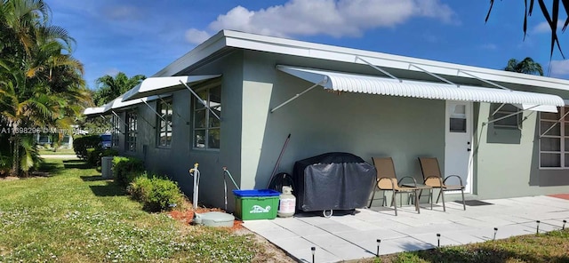 back of house featuring a lawn and a patio area