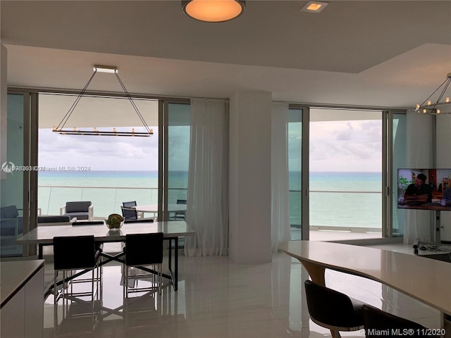 dining space with tile patterned flooring and a water view