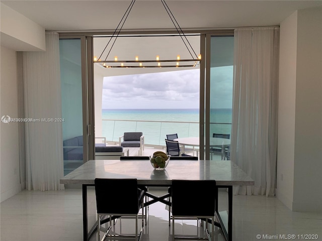 dining space with a notable chandelier and a water view