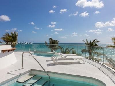 view of pool featuring a water view and a hot tub