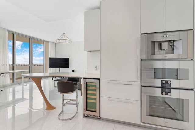 16901 Collins Ave Unit 1402, Sunny Isles Beach, FL 33160 - kitchen with beverage cooler, light countertops, white cabinets, modern cabinets, and expansive windows