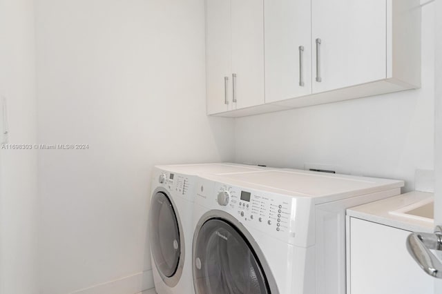 laundry area with cabinets and washing machine and clothes dryer