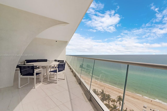 balcony featuring a water view and a beach view