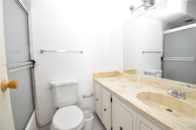 full bathroom featuring combined bath / shower with glass door, tile patterned floors, vanity, and toilet