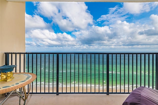 balcony featuring a beach view and a water view