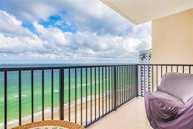 balcony featuring a water view and a beach view